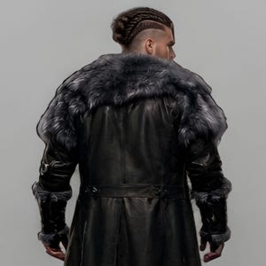 Black leather Viking armor costume with a long fur-trimmed medieval coat, sleeveless inner armor vest, layered leather panels, wide waist belt, fur-trimmed shoulders, long sleeves, adjustable straps, and matching leather leg armor. Rugged Norse-inspired outfit for men, ideal for Halloween, Viking cosplay, LARP, Renaissance fairs, medieval festivals, fantasy conventions, winter events, themed parties, and photoshoots. Handmade with custom sizing and customization options.