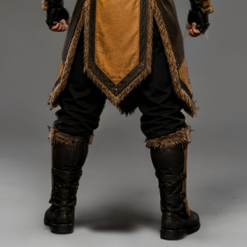 Black leather Viking ninja armor costume with antique gold leather panels, fur-trimmed shoulders, deep hood, adjustable waist belt, layered front armor, matching leather arm bracers, wrist guards and lower leg armor. Handmade medieval fantasy outfit with a rugged warrior-inspired design, suitable for Halloween, LARP, cosplay, Renaissance fairs, conventions, themed parties and fantasy photoshoots. Custom sizing and color options available.