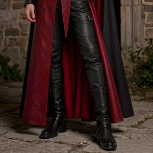 Men’s red and black Gothic vampire leather coat featuring a high standing collar, black fur-trimmed shoulders, double-breasted button detailing, wide waist belt, cross-body leather strap, long sleeves, and a dramatic floor-length silhouette. The dark Victorian-inspired design creates a Vampire Lord look ideal for Halloween, gothic cosplay, LARP, Renaissance fairs, masquerade events, fantasy conventions, stage performances, costume parties, and themed photoshoots.