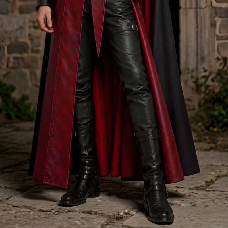 Men’s red and black Gothic vampire leather coat featuring a high standing collar, black fur-trimmed shoulders, double-breasted button detailing, wide waist belt, cross-body leather strap, long sleeves, and a dramatic floor-length silhouette. The dark Victorian-inspired design creates a Vampire Lord look ideal for Halloween, gothic cosplay, LARP, Renaissance fairs, masquerade events, fantasy conventions, stage performances, costume parties, and themed photoshoots.