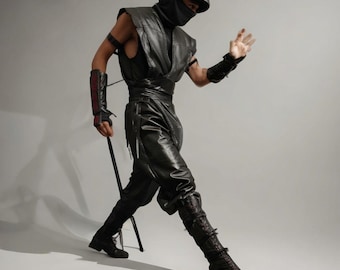 May include: A black faux leather ninja costume featuring a sleeveless hooded tunic, a face mask, a wide waist sash, and matching trousers. The outfit includes forearm guards with red accents and tall, lace-up boots, creating a complete ensemble.
