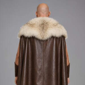 Men’s brown Viking leather tunic with a full-length matching cloak, large light fur shoulder collar, lace-up neckline, wide leather belt, front utility pockets, and matching leather forearm bracers. Front and back views show the sleeveless Norse warrior tunic and long flowing fur-trimmed cloak. Ideal for Viking cosplay, medieval LARP, Renaissance fairs, Halloween, fantasy conventions, stage costumes, and Norse warrior events.