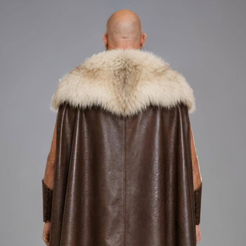 Men’s brown Viking leather tunic with a full-length matching cloak, large light fur shoulder collar, lace-up neckline, wide leather belt, front utility pockets, and matching leather forearm bracers. Front and back views show the sleeveless Norse warrior tunic and long flowing fur-trimmed cloak. Ideal for Viking cosplay, medieval LARP, Renaissance fairs, Halloween, fantasy conventions, stage costumes, and Norse warrior events.