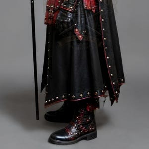 Black leather plague doctor costume coat with gothic and steampunk styling, red leather details, layered shoulder armor, straps, rivets, long sleeves, gloves and matching bracers. Dark fantasy medieval inspired cosplay outfit for Halloween, LARP, Renaissance fairs, photoshoots, festivals and costume parties. Handmade leather outerwear with a dramatic plague doctor aesthetic and customizable fit. Hat, plague doctor mask, bags, staff and accessories are not included and can be ordered separately.!