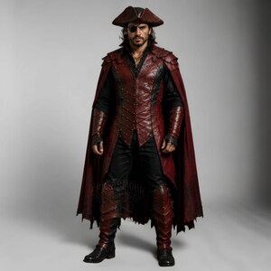 Men's leather pirate costume in dark red and black, featuring a detailed leather vest, layered shoulder armor, arm bracers, leg armor, and flowing cape. Handmade pirate cosplay outfit for Halloween, LARP, Renaissance fairs, medieval fantasy events, themed parties, festivals, conventions, stage performances, and photoshoots. Custom sizing, colors, length, and design options available. Dark fantasy pirate captain costume with wearable leather armor and handcrafted details.
