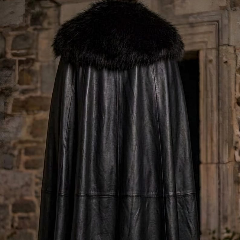 Men’s red and black Gothic vampire leather coat featuring a high standing collar, black fur-trimmed shoulders, double-breasted button detailing, wide waist belt, cross-body leather strap, long sleeves, and a dramatic floor-length silhouette. The dark Victorian-inspired design creates a Vampire Lord look ideal for Halloween, gothic cosplay, LARP, Renaissance fairs, masquerade events, fantasy conventions, stage performances, costume parties, and themed photoshoots.
