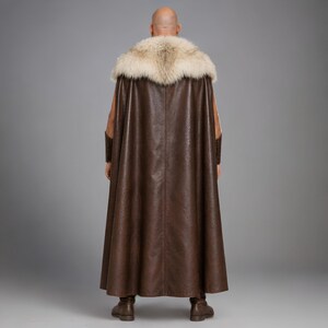 Men’s brown Viking leather tunic with a full-length matching cloak, large light fur shoulder collar, lace-up neckline, wide leather belt, front utility pockets, and matching leather forearm bracers. Front and back views show the sleeveless Norse warrior tunic and long flowing fur-trimmed cloak. Ideal for Viking cosplay, medieval LARP, Renaissance fairs, Halloween, fantasy conventions, stage costumes, and Norse warrior events.