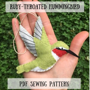 May include: A felt ruby-throated hummingbird ornament with light green wings, a white belly, and a red throat patch, featuring a black beak and a hanging string. The text reads RUBY-THROATED HUMMINGBIRD and PDF SEWING PATTERN, with the logo MADE KNOWN LOVED Art.