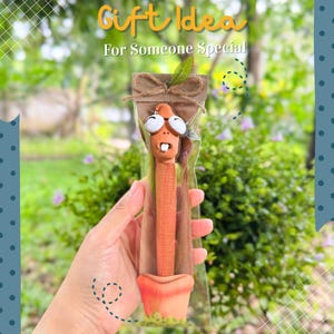 以下が含まれることがあります： テラコッタの鉢に入った、手作りの気まぐれなミミズの置物。ギフトとしてパッケージされています。ミミズは大きな漫画の目と小さな口をしています。パッケージには「Gift Idea For Someone Special」の文字が入っています。