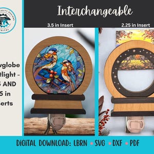 Może przedstawiać: Drewniana lampka nocna w kształcie kuli śnieżnej z wymiennymi wkładkami. Jedna wkładka przedstawia witraż z dwoma ptakami. Druga wkładka ma scenę krajobrazową. Lampka nocna jest przeznaczona do podłączenia do gniazdka ściennego. U góry znajduje się napis "Interchangeable".