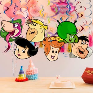 May include: A festive birthday scene with cartoon character cutouts, party hats, and a cake. The characters include Fred, Wilma, Barney, Betty, and Dino. Colorful balloons and streamers decorate the background, creating a celebratory atmosphere.