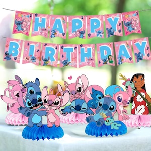 May include: A festive birthday party decoration set featuring a banner that reads "HAPPY BIRTHDAY" in blue letters on pink pennants. The set includes character cutouts of Stitch and Angel, with blue and pink honeycomb centerpieces.