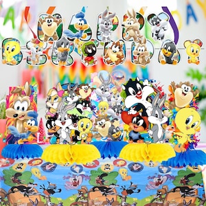 May include: A colorful Looney Tunes-themed party decoration set. Includes a banner with character cutouts, table centerpieces, and a tablecloth featuring various cartoon characters. The decorations are vibrant and suitable for a birthday celebration.