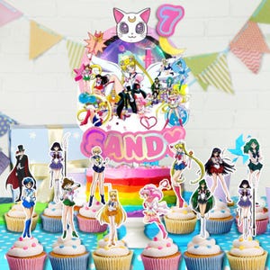 May include: A colorful birthday cake with a rainbow design, topped with anime character decorations and the number 7. Cupcakes with character toppers are arranged in front of the cake, with a banner in the background.