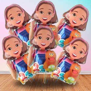 May include: A collection of foil balloons featuring a cartoon girl with brown hair and a pink headband, wearing a pink shirt and blue overalls. Each balloon has a cartoon character and a number.