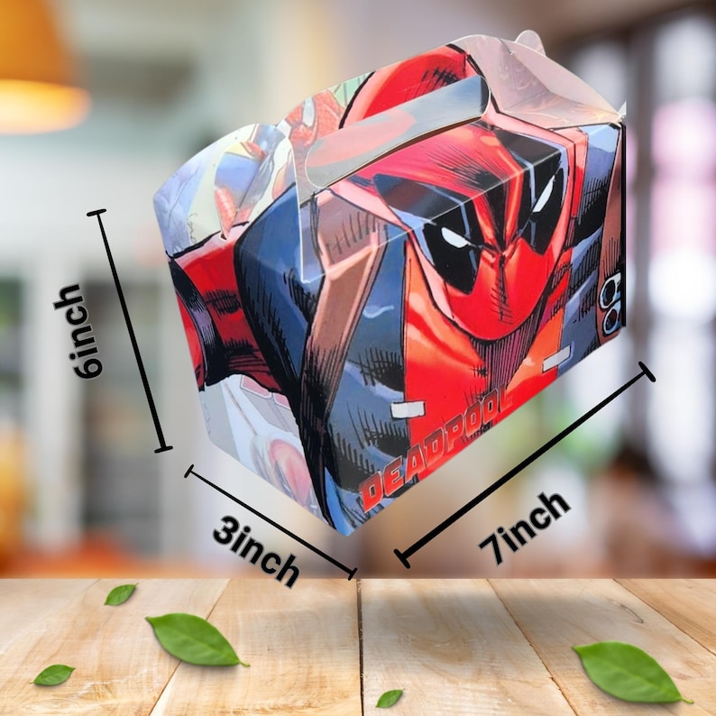 May include: A rectangular box with a Deadpool comic book design. The box is red, black, and blue, with the word "Deadpool" printed on the side. The box measures 17.78 cm long, 15.24 cm high, and 7.62 cm wide.