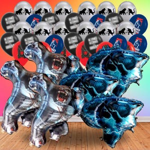 May include: A collection of party balloons and foil balloons featuring King Kong and Godzilla. The balloons include silver, black, red, and blue colors. Some balloons have the text "King Kong vs Godzilla". The foil balloons are shaped like the characters.