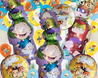 May include: A collection of colorful Rugrats-themed balloons. The balloons feature characters like Tommy, Chuckie, and Angelica. There are various shapes, including round and character-shaped balloons, in shades of purple, green, yellow, and blue. Perfect for a birthday party.