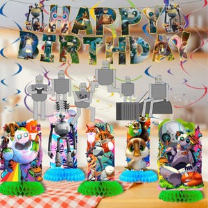 May include: A festive birthday party decoration set featuring a banner that spells "HAPPY BIRTHDAY" with colorful illustrations. The set includes several robot-themed centerpieces with cartoon characters and a red and white checkered tablecloth.