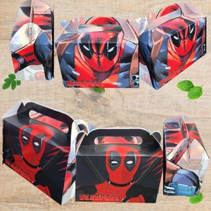 May include: Six Deadpool-themed gift boxes. Each box features a red and black design with the Deadpool character's face and the word "DEADPOOL" in white. The boxes are made of cardboard and have a handle for carrying.