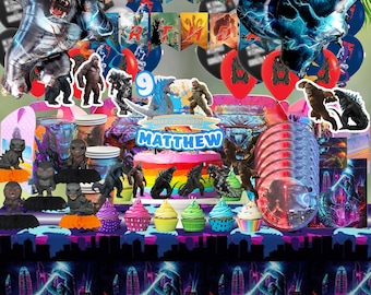 May include: A colorful birthday party scene with Godzilla and King Kong themed decorations. Includes foil balloons, banners, cake, cupcakes, and figurines. The cake topper reads "Happy Birthday Matthew".