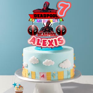 Puede incluir: Un pastel azul claro decorado con detalles de nubes blancas y un adorno tem&aacute;tico de Deadpool. El adorno incluye el nombre "Alexis", el n&uacute;mero "7" y las palabras "Happy Birthday". El pastel est&aacute; sobre un soporte blanco.