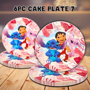May include: Set of six 7-inch cake plates featuring a colorful cartoon design. The plates have a pink and white floral background with images of a blue alien, a girl, and a pink alien. The text "6PC CAKE PLATE 7"" is at the top.