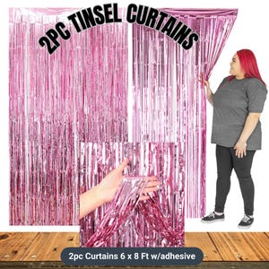 Puede incluir: Cortinas de oropel rosa, 183 cm x 244 cm, con adhesivo. La imagen muestra dos juegos de cortinas de oropel rosa. El texto en la imagen dice "2PC TINSEL CURTAINS". Una persona sostiene la cortina.