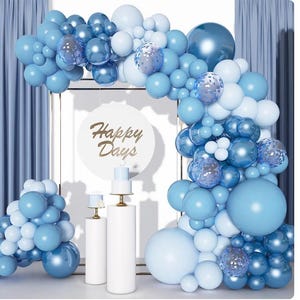 May include: A festive balloon arch in shades of blue and white, with a backdrop of blue curtains. The arch features various sizes of balloons, including some with a transparent, glittery effect. A sign with the words "Happy Days" is in the center.