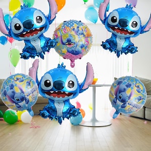May include: A collection of blue Stitch-shaped foil balloons and round balloons featuring Stitch. The balloons are in a room with a table and other colorful balloons. The Stitch balloons have large ears and a smiling face.
