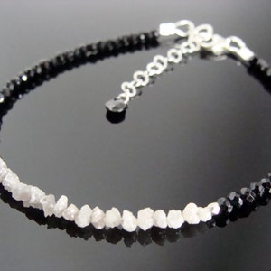 May include: A silver chain bracelet with black and white beads. The black beads are faceted and the white beads are rough, unpolished diamonds.