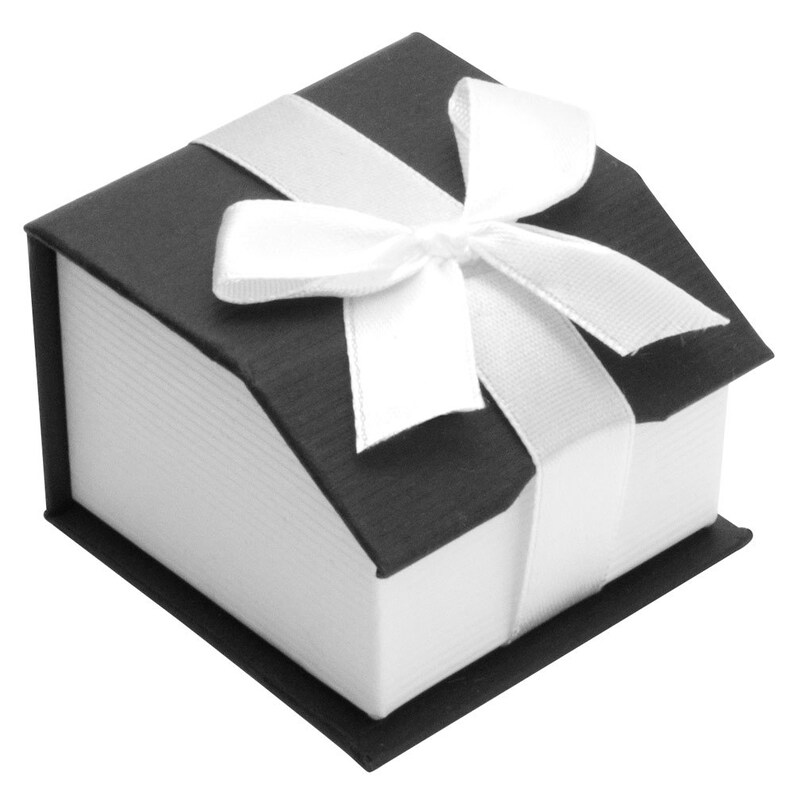 Puede incluir: Una peque&ntilde;a caja de regalo negra con una cinta de sat&eacute;n blanca y un lazo.