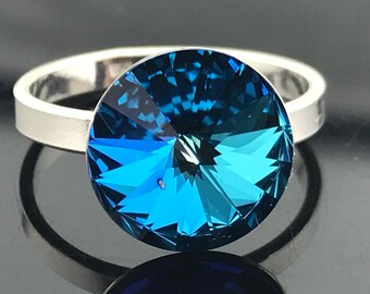 Peut inclure: Une bague en argent avec une grosse pierre ronde en cristal bleu.