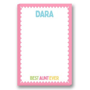 May include: A pink notepad with a scalloped edge. The name "DARA" is printed in blue at the top, and the phrase "BEST AUNT EVER" is at the bottom in green, yellow, and orange. The notepad is rectangular with a white interior.