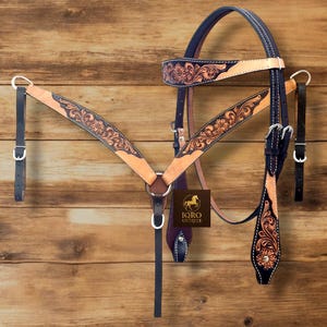 May include: A handcrafted horse tack set featuring a headstall, breast collar, and reins. The set is made of tan leather with intricate floral tooling and dark blue accents. The set includes silver-tone buckles and hardware. The brand logo "IQRO UNIQUE" is visible.