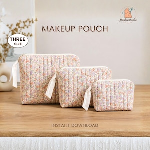 May include: Three quilted makeup pouches in varying sizes, featuring a floral pattern with small pink, purple, and orange flowers on a cream background. Each pouch has vertical stitching, a white zipper, and a white fabric pull tab. Text reads MAKEUP POUCH, THREE SIZE, INSTANT DOWNLOAD, and Sticheestudio.