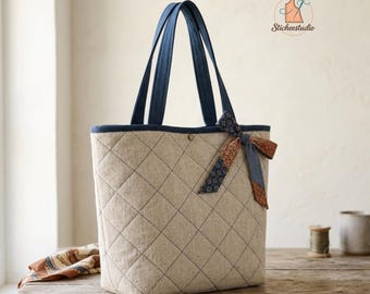 May include: A quilted tote bag featuring a beige diamond-stitched pattern, dark blue fabric handles, and a decorative bow tied on the front. The text QUILTED TOTE BAG and INSTANT DOWNLOAD are visible, along with a logo featuring a needle and thread.