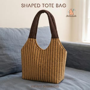 May include: A shaped tote bag featuring a mustard yellow and dark brown vertical striped pattern. The bag has two dark brown handles and is labeled with the text SHAPED TOTE BAG and INSTANT DOWNLOAD, along with a Sticheestudio logo icon.