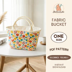 Puede incluir: Un bolso tipo cubo de tela acolchada con fondo crema y un patrón colorido de piñas amarillas, pitayas rojas y bayas azules. El texto a la derecha dice Sticheestudio, FABRIC BUCKET, ONE SIZE, PDF PATTERN, BEGINNER FRIENDLY, INSTANT DOWNLOAD.