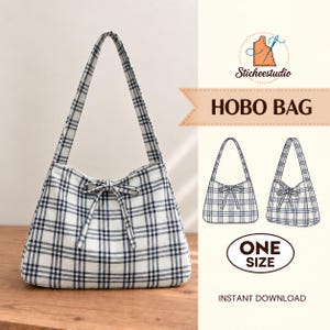 Op de afbeelding: Een hobo-tas van witte stof met een donkerblauw en zwart ruitpatroon, een enkele schouderband en een decoratieve strik aan de voorzijde. De afbeelding bevat de tekst Sticheestudio, HOBO BAG, ONE SIZE en INSTANT DOWNLOAD.