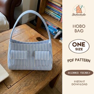 May include: A hobo bag featuring a light blue and white vertical striped pattern with two front pockets and a single shoulder strap. The text on the right reads Sticheestudio HOBO BAG ONE SIZE PDF PATTERN BEGINNER FRIENDLY INSTANT DOWNLOAD.