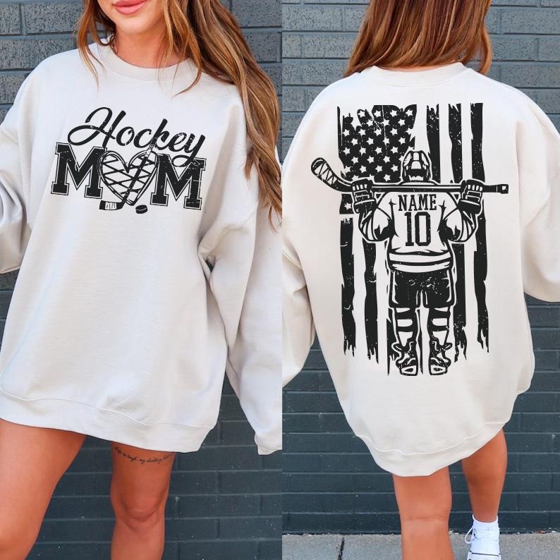 A white sweatshirt with a graphic design on the back, featuring a hockey player and an American flag.