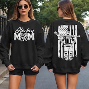 A woman wearing a black sweatshirt with a white design on the front and back.