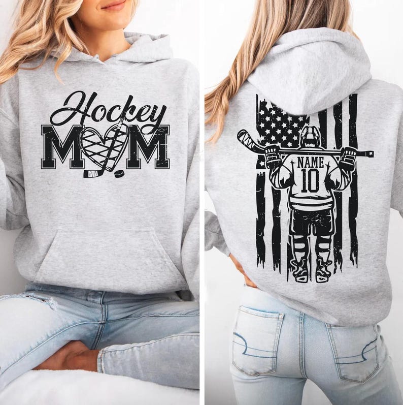 A woman wearing a grey hoodie with a graphic design on the front and a graphic on the back.