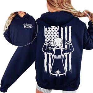 A navy blue hoodie with a white graphic design on the back, depicting a muscular figure with an American flag pattern.