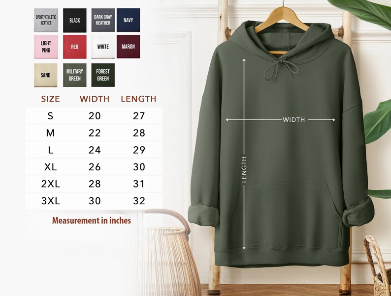a green hoodie hanging on a hanger, with a size chart and measurements provided. The chart lists the size options and corresponding measurements, such as S, M, L, XL, 2XL, and 3XL, along with the corresponding widths. The image also includes a plant in the background, adding a natural element to the scene.