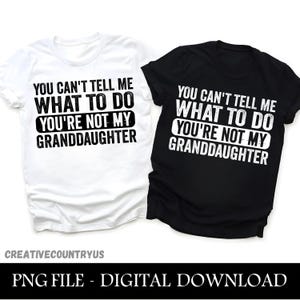 Può includere: Due magliette, una bianca e una nera, ciascuna con la scritta "YOU CAN'T TELL ME WHAT TO DO YOU'RE NOT MY GRANDDAUGHTER" in grassetto. La maglietta bianca ha il testo nero, e la maglietta nera ha il testo bianco.