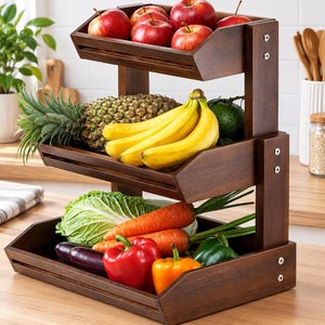 May include: A three-tiered dark brown wooden storage stand holding various fresh produce. The top shelf contains red apples, the middle shelf holds a pineapple and yellow bananas, and the bottom shelf features cabbage, carrots, and peppers.