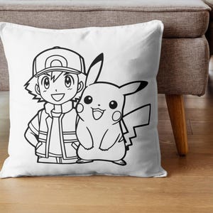 May include: White square pillow featuring a black and white illustration of a cartoon character with a cap and a smiling Pikachu. The pillow is placed on a wooden floor.