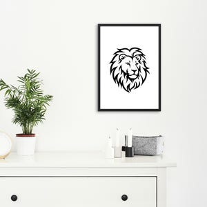 May include: Black and white framed art print featuring a detailed lion's head. The artwork is displayed on a white wall above a white dresser, alongside a potted plant and decorative items.